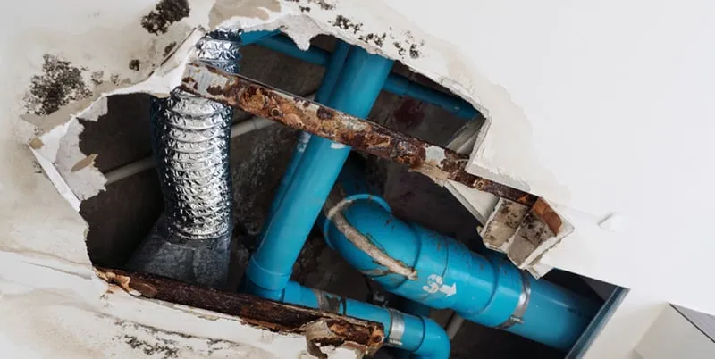 Burst pipe behind an opened wall
