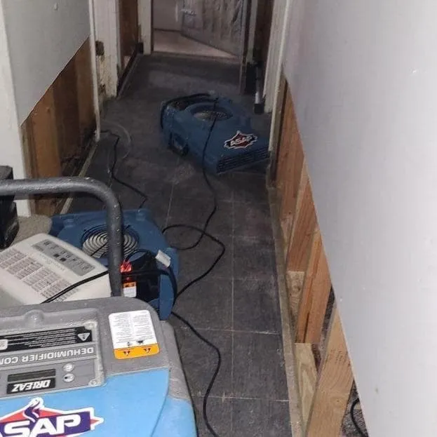 ASAP dehumidifier and air mover drying a basement hallway