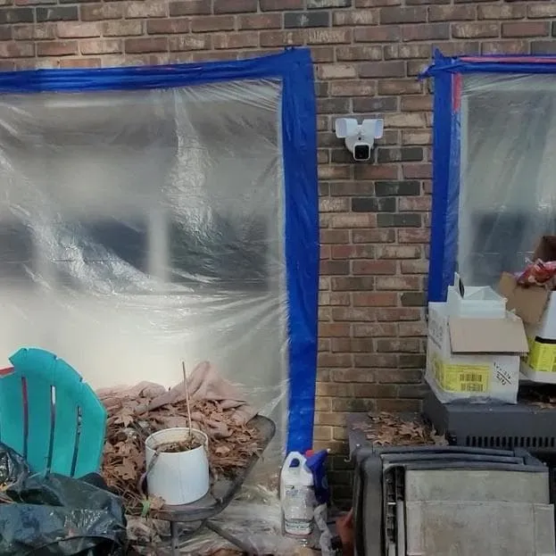 Plastic containment sealed over a doorway with blue tape