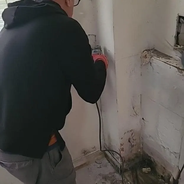 Technician removing damaged wall material