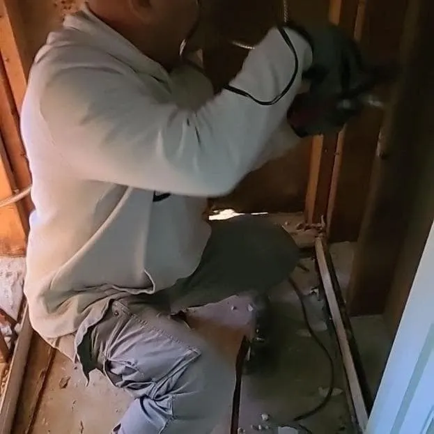 Technician cutting out contaminated drywall