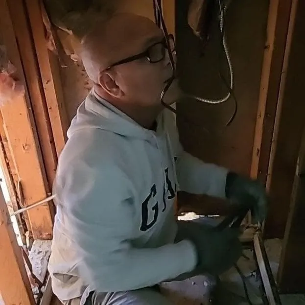 Technician cutting out wet drywall