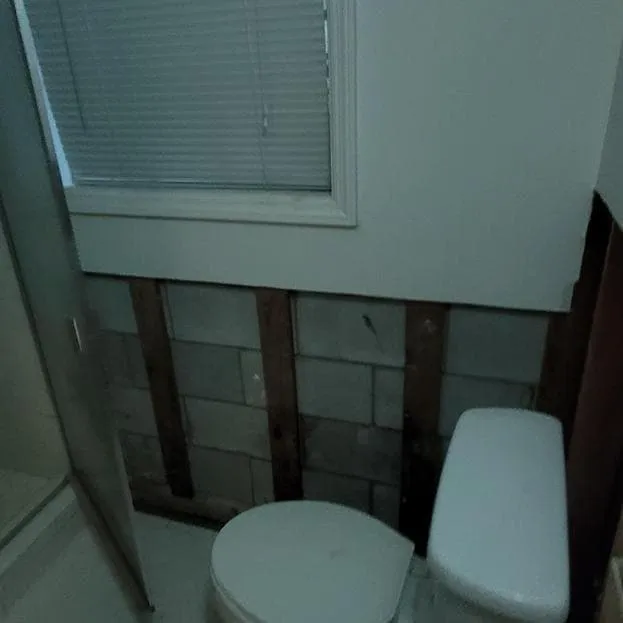 Bathroom with drywall removed at the base