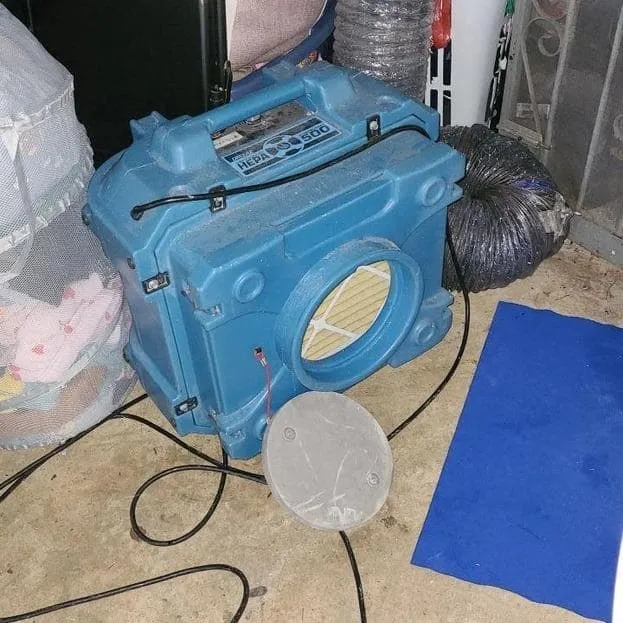 HEPA air scrubber running in an opened basement room